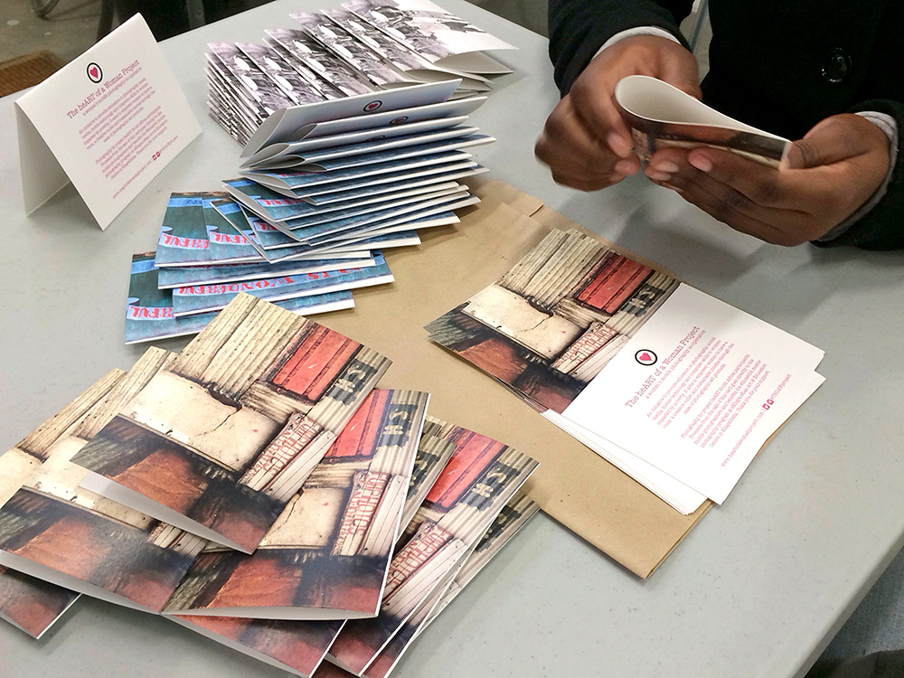 A participant in The Heart of a Woman Project in South Africa folds greeting cards, the newest product that launched in May 2014. At the end of the 11-day workshop in November 2013 each participant was given 200 postcards of one of their images to sell in the on-site boutique at eKhaya eKasi. Both products are currently sold in the boutique, globally through the website and at The Backpack, an award-winning hostel in Cape Town. It was revealed at the first anniversary photography exhibition and celebration in November 2014 that this program is the highest income generator.