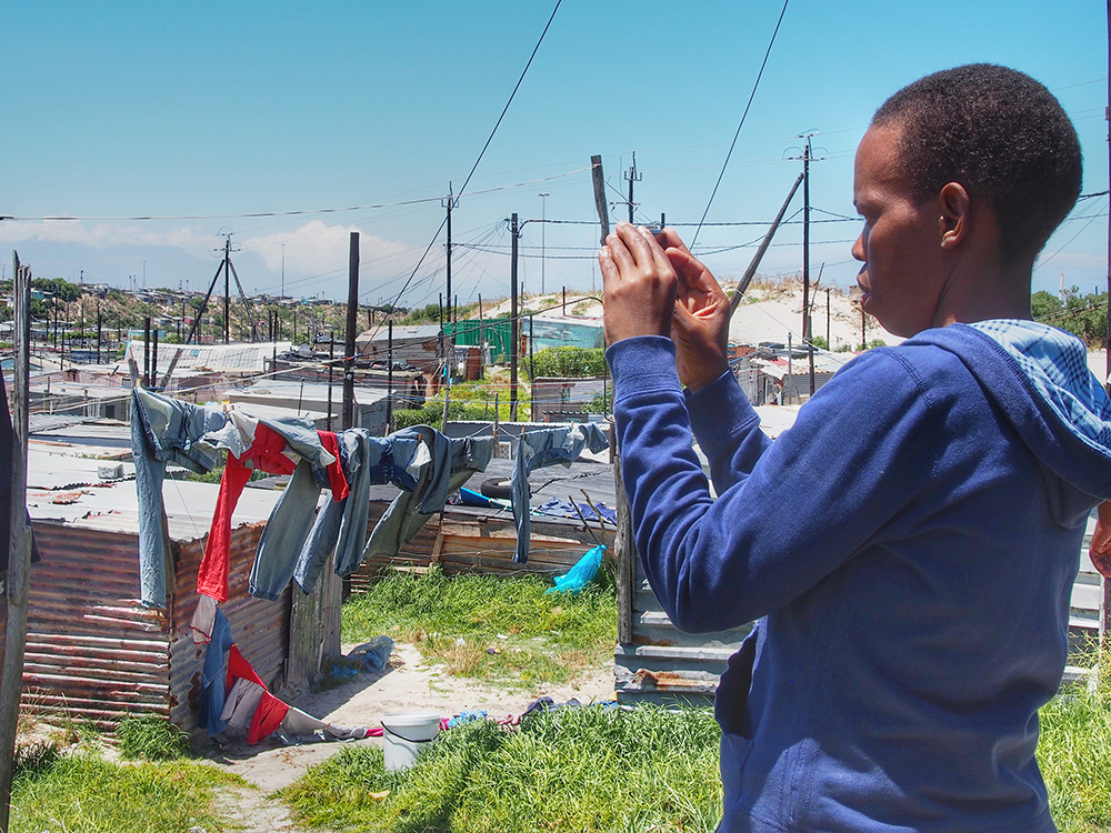 Retsepile Tom, founding member of The Heart of a Woman Project photographs an informal settlement. The population of Khayelitsha is speculated to be over 1 million people. It is difficult to count the numbers as there are several areas where informal settlements are housed. This one has an approximate population of 11,000 people.